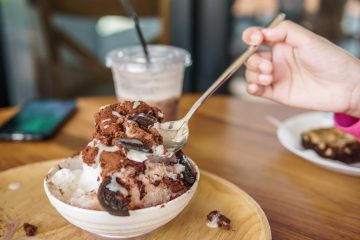 Chocolate ice cream with cookies on a wooden plate