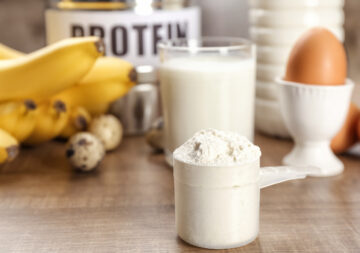 Pea protein powder in front of bananas, milk and a boiled egg