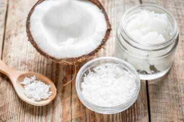 Fresh coconut and coconut oil on an old wooden table.