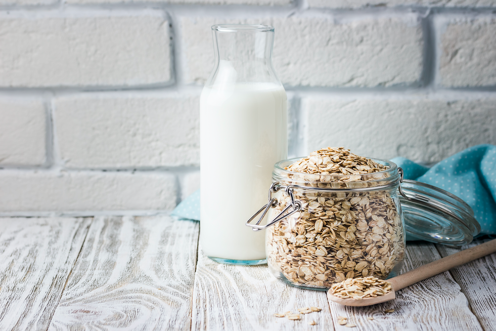 oat milk sitting next to jar of oats