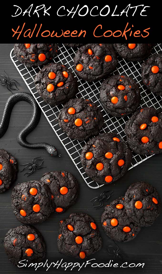 Cooling tray filled with very dark cookies with orange m&ms