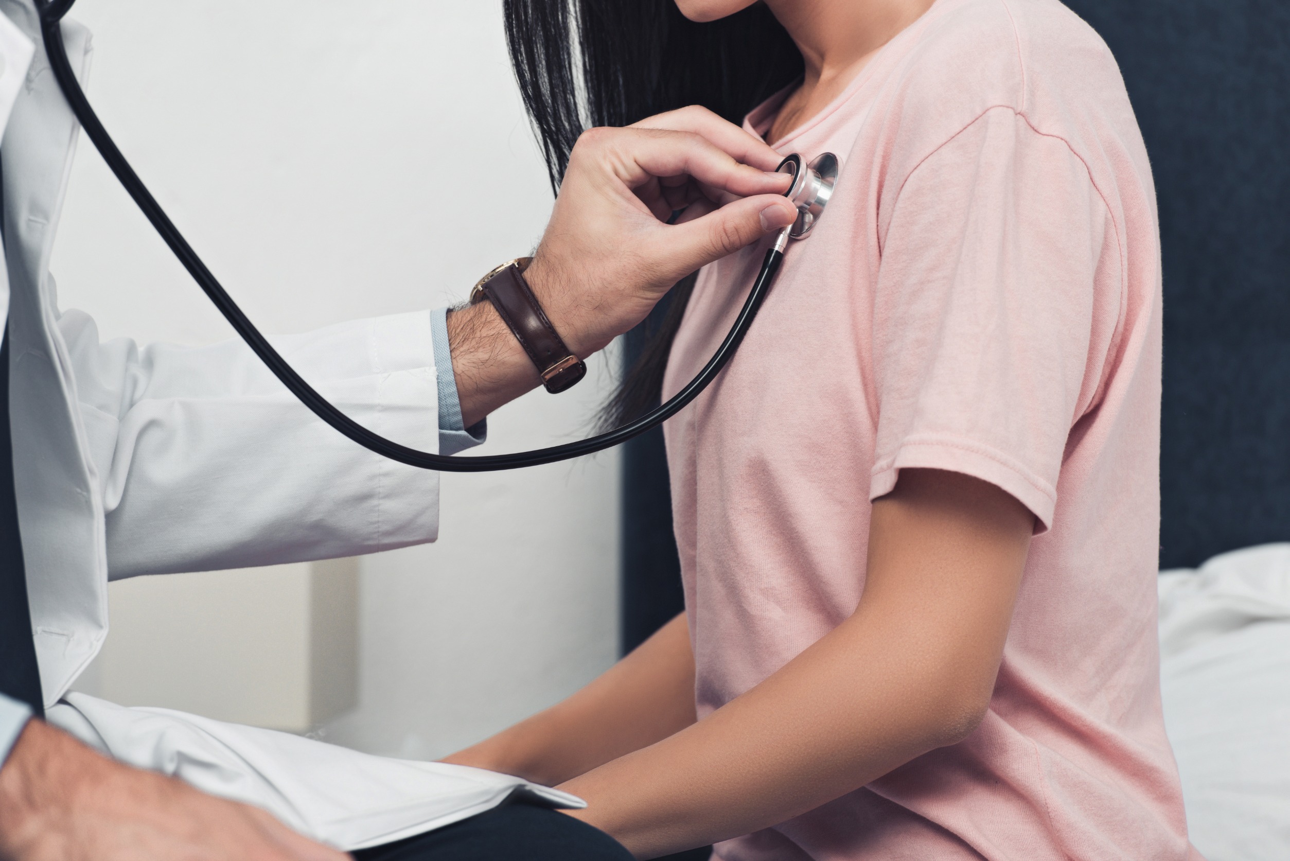 Doctor listening to patient’s breathing and heartbeat with a stethoscope