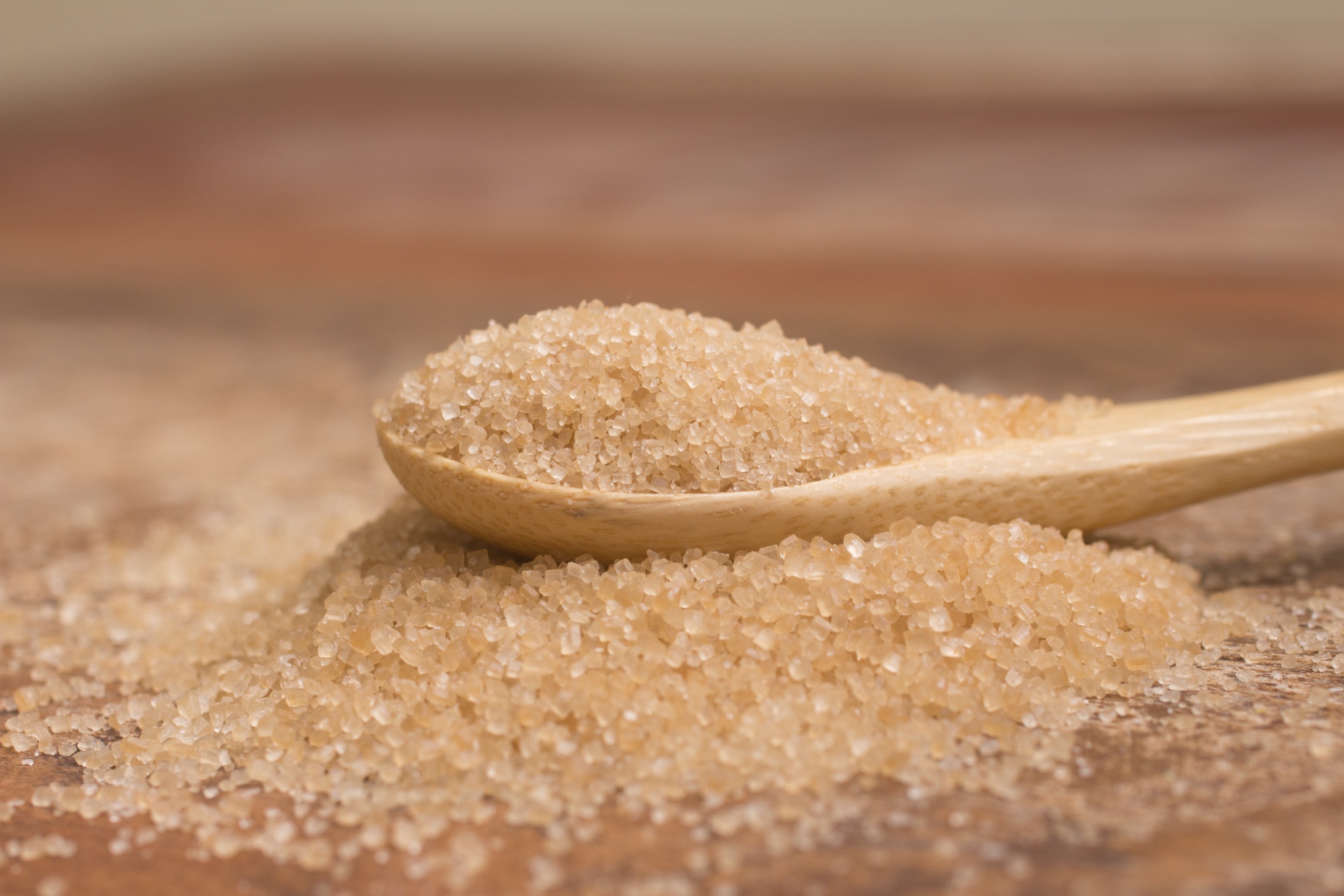 Natural cane sugar from a sauce ingredient supplier in a wooden spoon