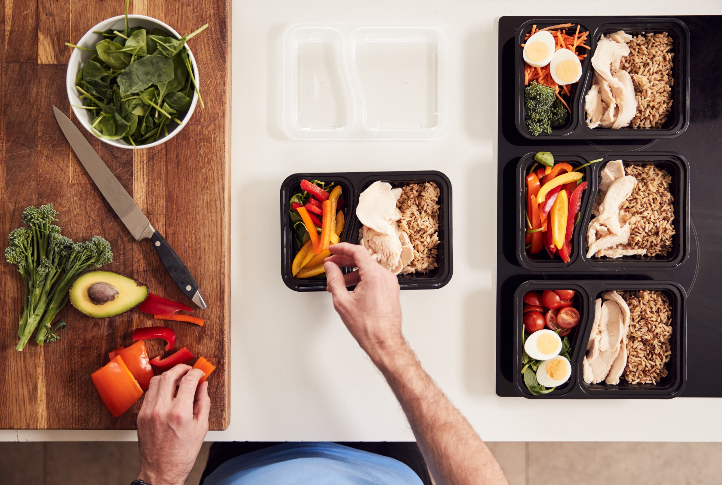 Overhead shot of man’s hands preparing meals from a ready-to-eat ingredient supplier