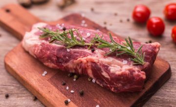 Gillco ingredients meat solutions with a raw seasoned steak on a wooden cutting board