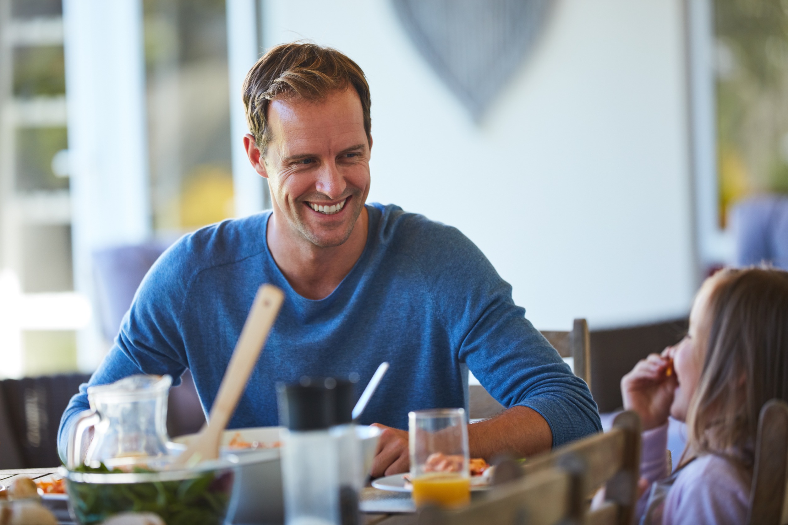 Father smiling with his daughter over breakfast