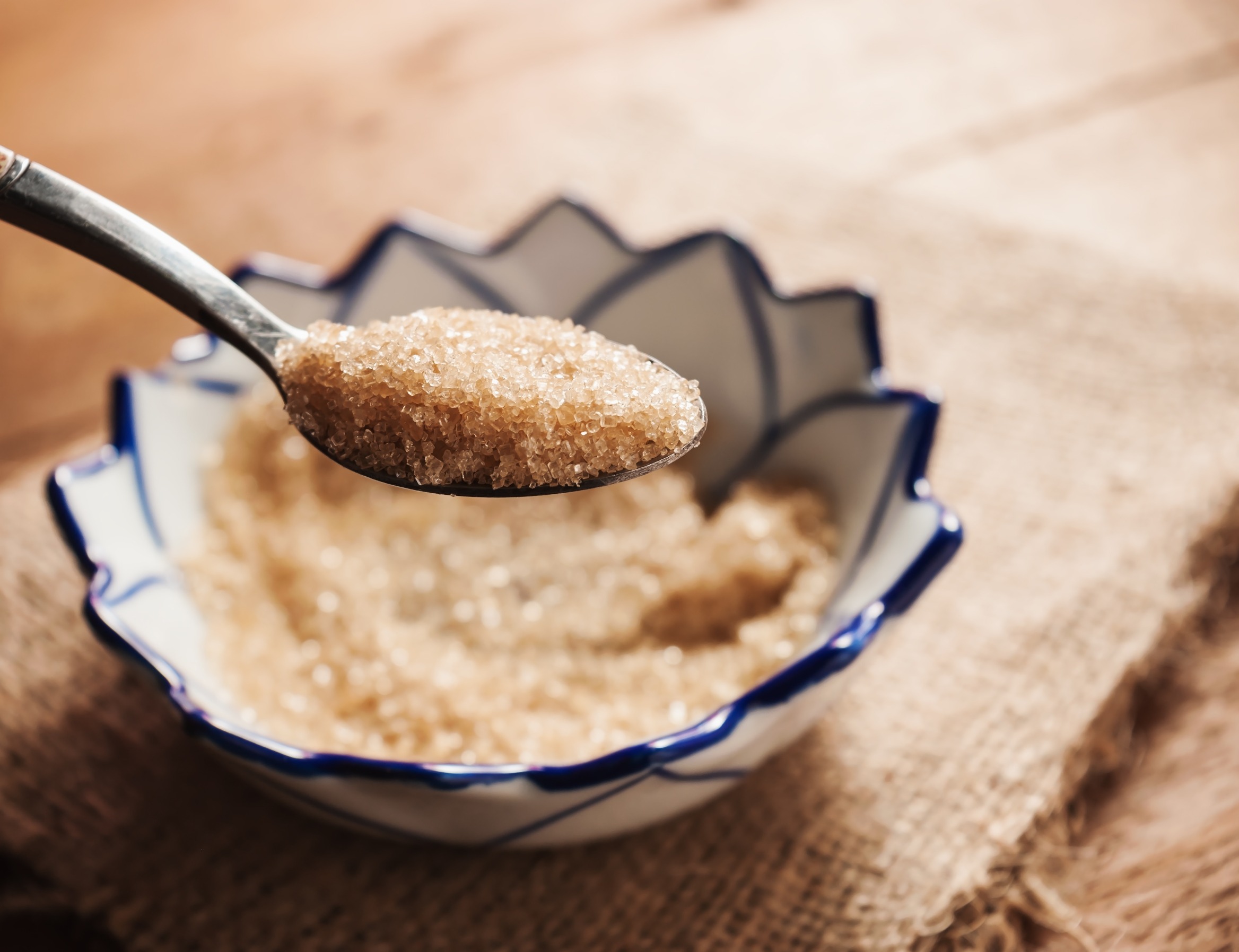 organic sugar in a spoon over a bowl