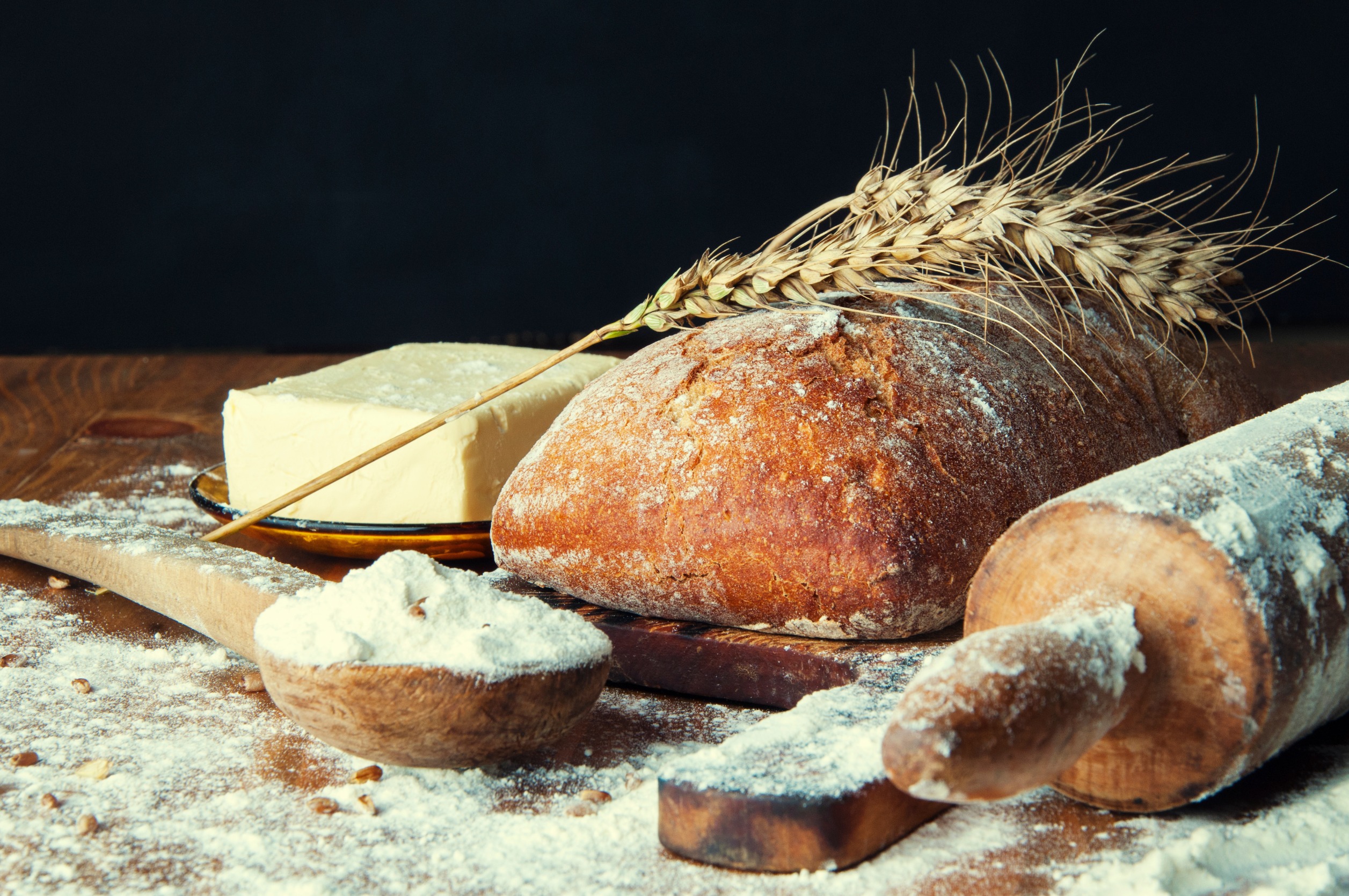 Fresh bread made with lecithin as an emulsifier on a wooden table with flour and butter