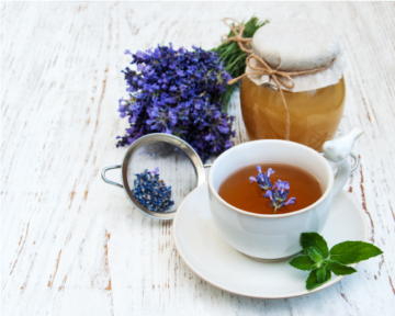 lavender tea in a white cup on a white wooden table