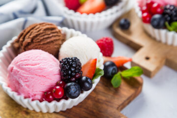 Selection of colorful ice cream scoops in white bowls, copy space