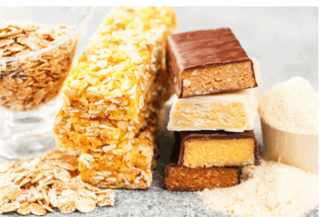 stack of protein bars next to a scoop of casein protein powder