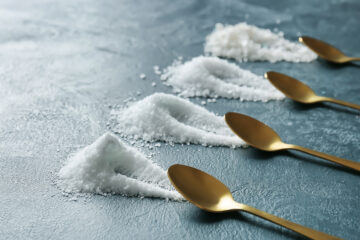 Different options of sea salt on a table with golden spoons